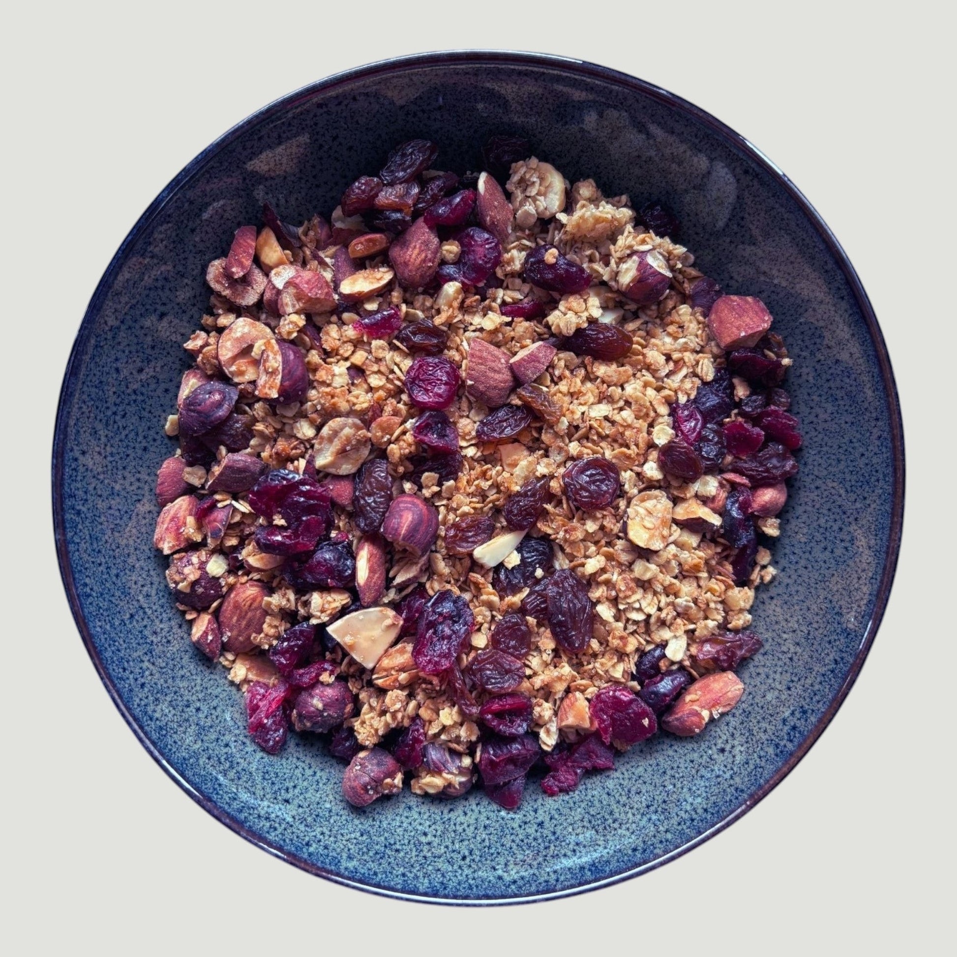 Granola artisanal Maison L'Allure aux flocons d'avoine, amandes, cranberries et miel dans un bol bleu.